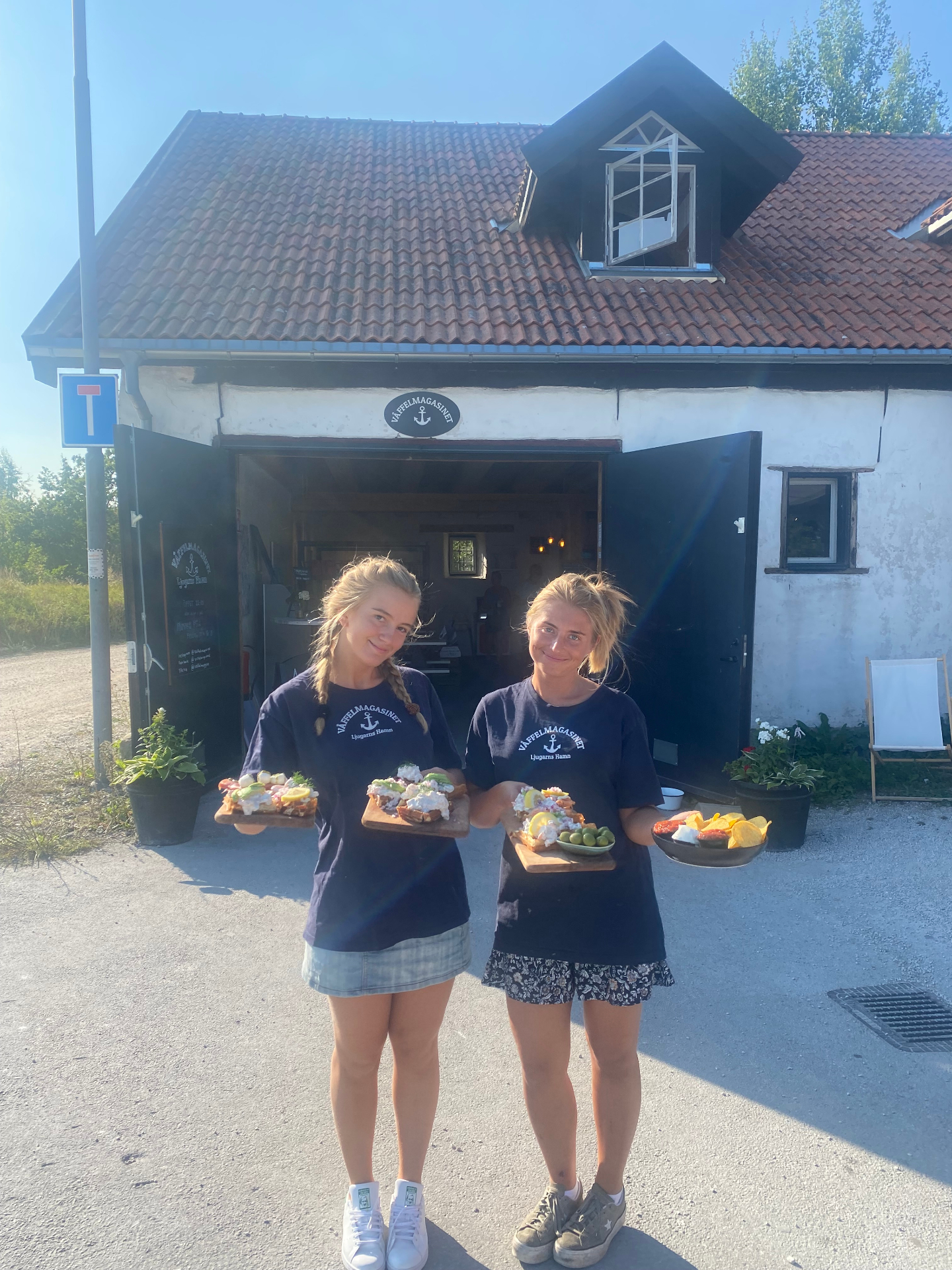 Personal med smörrebröd utanför ladan